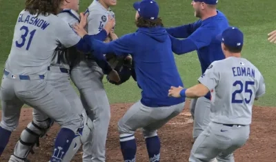 El lanzdor japonés Yoshinobu Yamamoto, Jugador Más Valioso de la Serie Mundial, es felicitado por sus compañeros al concluir el juego.