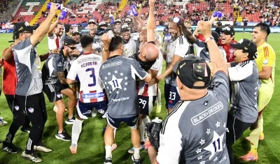 El técnico del Junior, Alfredo Arias, celebra el título con sus jugadores.