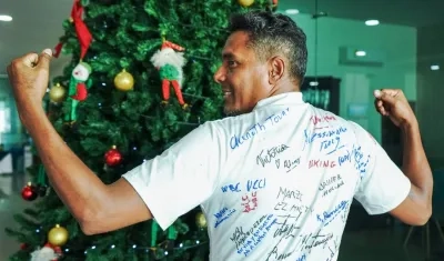 Lenin Utria con la camiseta firmada por los participantes en el Grand Prix. 
