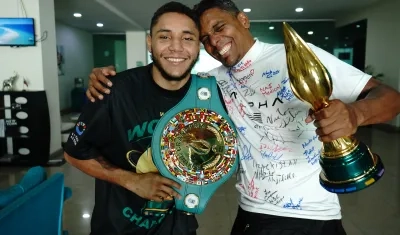 Carlos Utria con el cinturón de campeón y su papá y entrenador Lenin 
