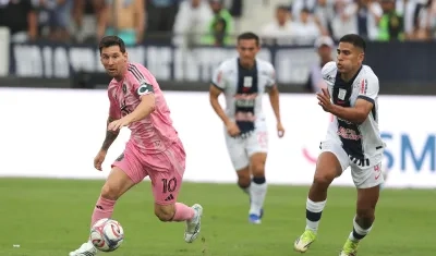 Gianfranco Chávez, de Alianza Lima, disputa el balón con Lionel Messi, de Inter Miami.