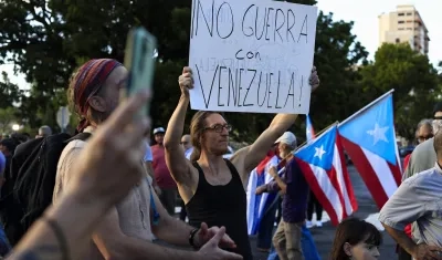 Un hombre sostiene un cartel durante una manifestación en apoyo a Venezuela en Puerto Rico. 