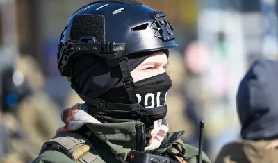 Un oficial federal hace guardia durante los enfrentamientos después de que ICE disparó fatalmente a un hombre varias veces mientras intentaban detenerlo en Minnesota.