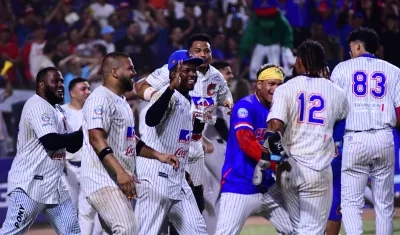 Carlos Arroyo (12) es felicitado por sus compañeros tras darle la victoria a Caimanes con un jonrón. 