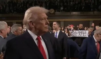 El Presidente Donald Trump y el congresista Al Green con el cartel.