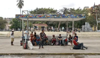 Personas esperan en un paradero de buses este martes, durante un apagón en La Habana. 