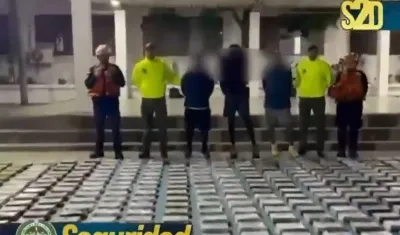 Las autoridades junto a parte de lo incautado y los tres capturados.