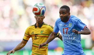 El congolés Cedric Bakambu disputa la pelota con el jamaiquino Richard King.
