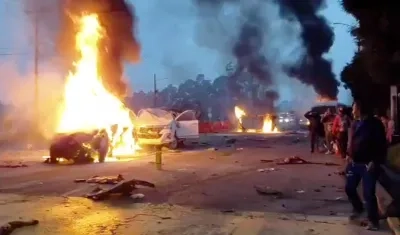 Los vehículos incendiados tras ser colisionados por la tractomula. 