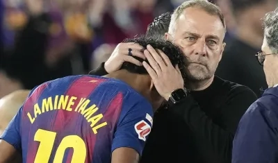 Lamine Yamal, autor del gol del Barcelona, es consolado por el técnico Hansi Flick tras salir de la cancha por lesión.
