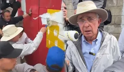 El expresidente Álvaro Uribe pintando sobre el mural.