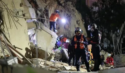 Integrantes de cuerpos de emergencia buscan víctimas.