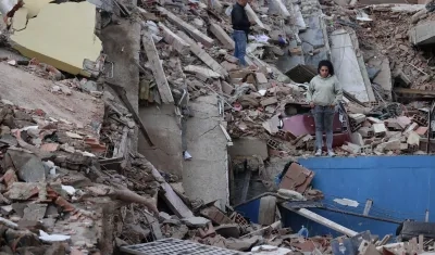 Residentes caminan entre los escombros de edificios derrumbados por los terremotos, en la localidad de Catia La Mar, en La Guaira.