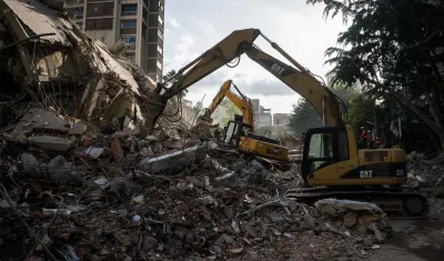 Integrantes de equipos de rescate trabajan en un edificio afectado.