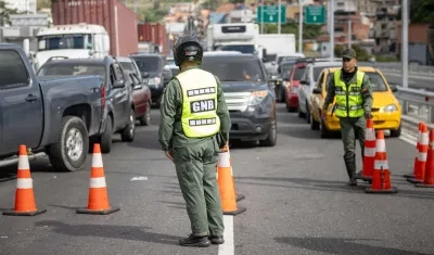 Integrantes de la Guardia Nacional Bolivariana custodian en la autopista bloqueada que conecta al estado La Guaira con Caracas.