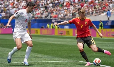 Kevin De Bruyne, de Bélgica, disputa el balón con Saeid Ezatolahi, de Irán.