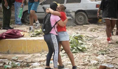 Personas lloran frente a escombros de edificios afectados por los terremotos 