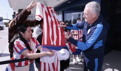 Gustavo Alfaro, técnico de Paraguay, firma camisetas a los aficionados.