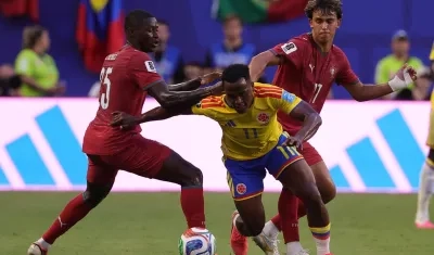 Jhon Arias intenta avanzar entre la marca de Nuno Mendes y Joao Félix.
