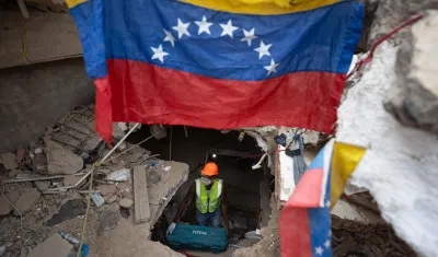 Una persona realiza labores de búsqueda entre los escombros de edificios destruidos por terremotos en La Guaira. 