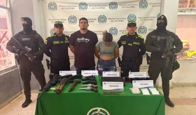 La pareja capturada junto con el arsenal de guerra incautado. 