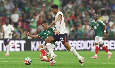  Erik Lira (i) de México disputa un balón con Jude Bellingham de Inglaterra