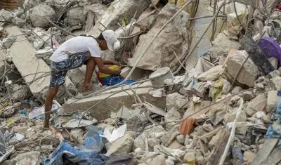 Una persona busca entre los escombros de edificios destruidos por terremotos.