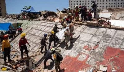 Rescatistas buscan cuerpos entre los escombros.