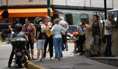 Personas esperan afuera de sus viviendas este viernes. 