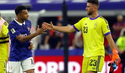 Kylian Mbappé se saluda con el portero español Unai Simón.