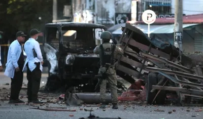 Policías inspeccionan el lugar donde ocurrió un atentado.