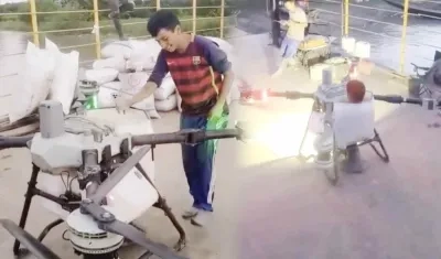 Joven sobre el dron aspersor.
