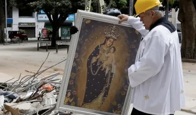 El padre Nelson Giraldo Mejía sostiene una réplica de la Virgen de Nuestra Señora de la Pobreza.