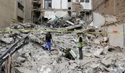 Personas observan los escombros del edificio Santiago Londoño, este viernes en Pereira. 