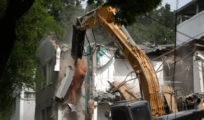 Retroexcavadora demoliendo un edificio.