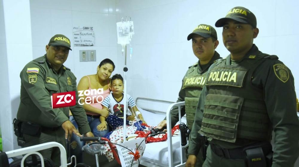 Patrulleros de la Policía entregando la bicicleta a Kevin.