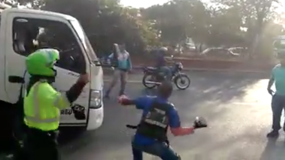 Momento en el que el motociclista lanza la piedra al vidrio del camión.