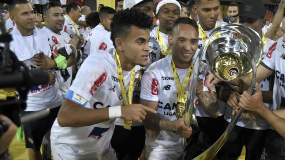 Luis Díaz con el trofeo de campeón, al lado de Jarlan Barrera. 