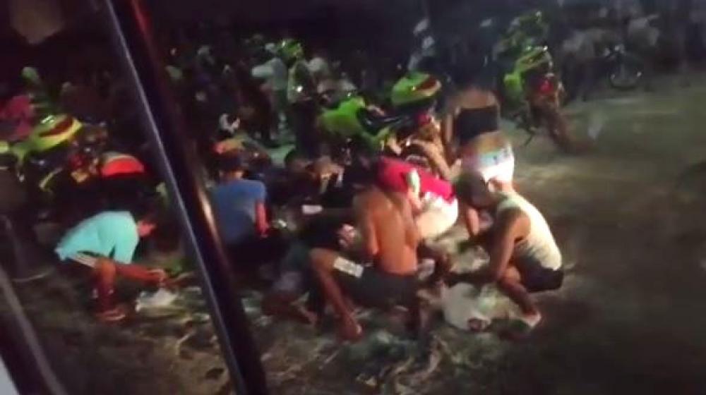 Vecinos recogiendo la carga de arroz que quedó regada en la vía.