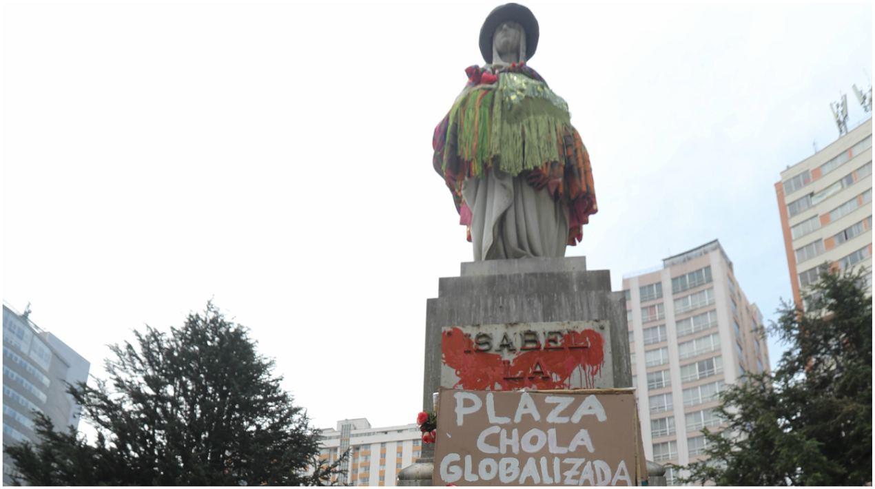 Las feministas colocaron a la imagen una pollera, una manta amarilla, un atado de aguayo y un sobrero, vestimenta de la mujer indígena aymara, como parte de la intervención por el Día de la Mujer (11 de Octubre) y el Día de la Descolonización (12 de Octubre). 