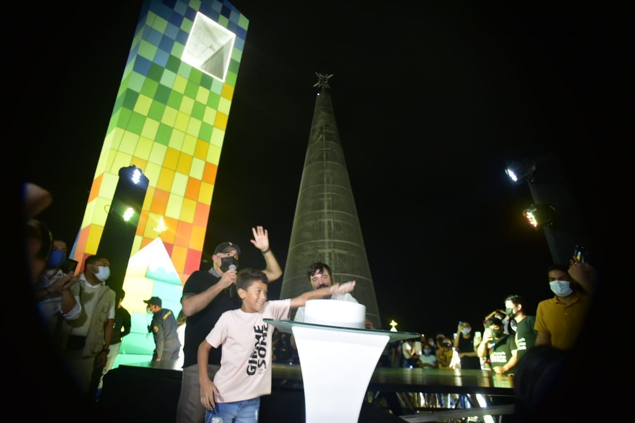 El pequeño Santiago encendiendo el gigantesco árbol navideño.