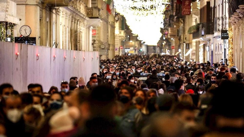 Decenas de personas aglomeradas para hacer compras navideñas en una calle de Roma.