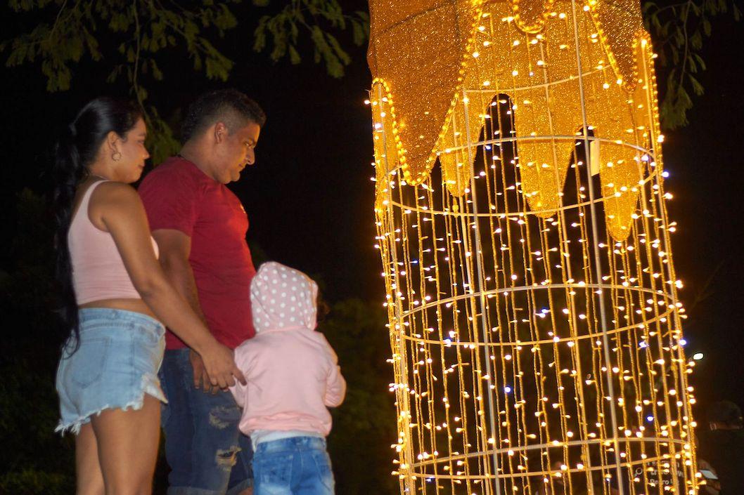 Adultos y niños disfrutando el alumbrado navideño.