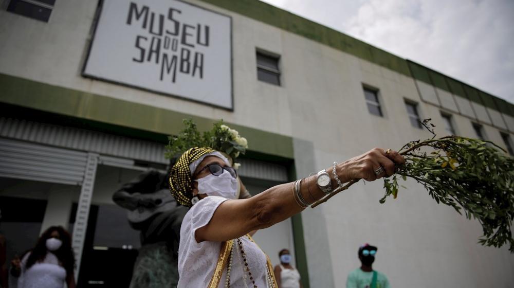Una mujer "limpia" los espíritus frente al Museo de Samba, durante una inauguración "simbólica del carnaval" hoy, en el Museo de Samba, en el barrio Mangueira de Río de Janeiro (Brasil).