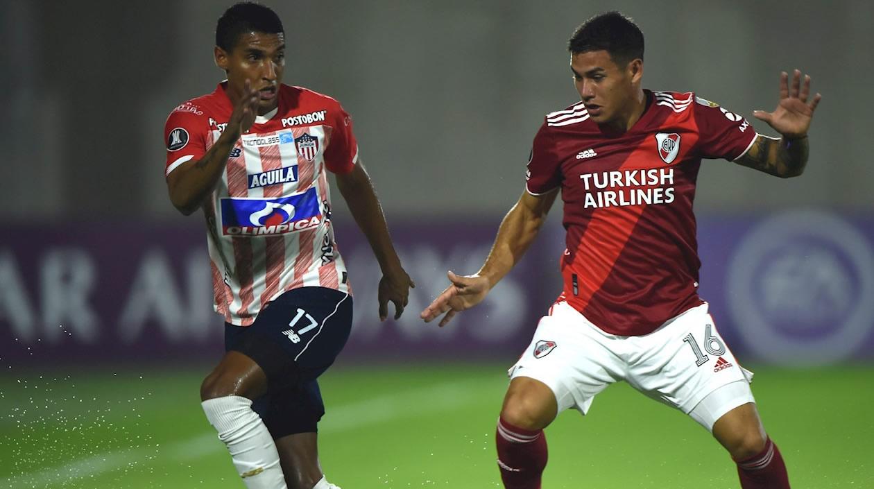 Gabriel Fuentes de Junior disputa un balón con Alex Vigo de River Plate