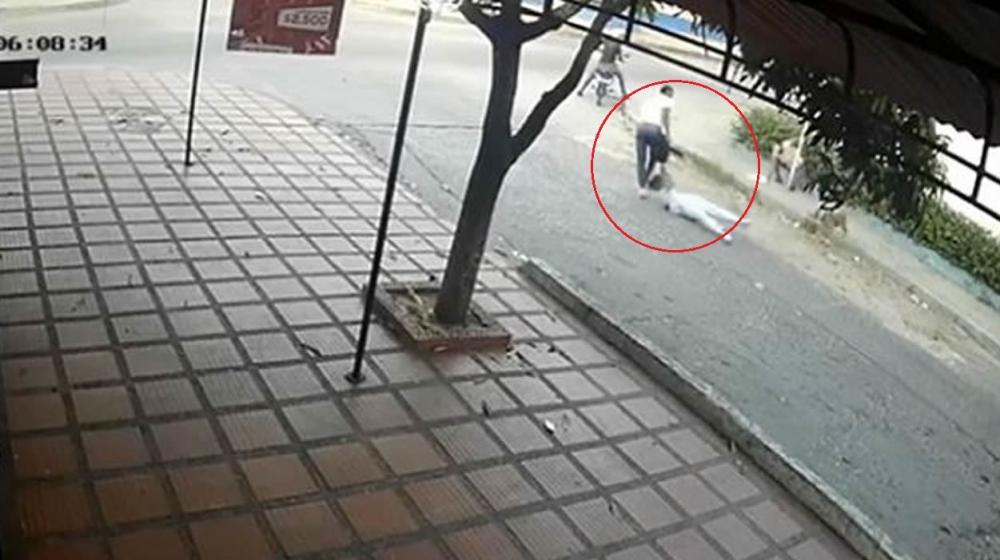 El delincuente arrastrando a la joven que intentaba atracar.