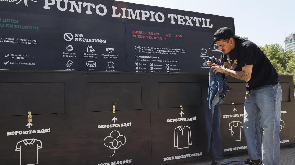 Un hombre deposita ropa usada en el "Punto Limpio Textil" en Santiago de Chile.