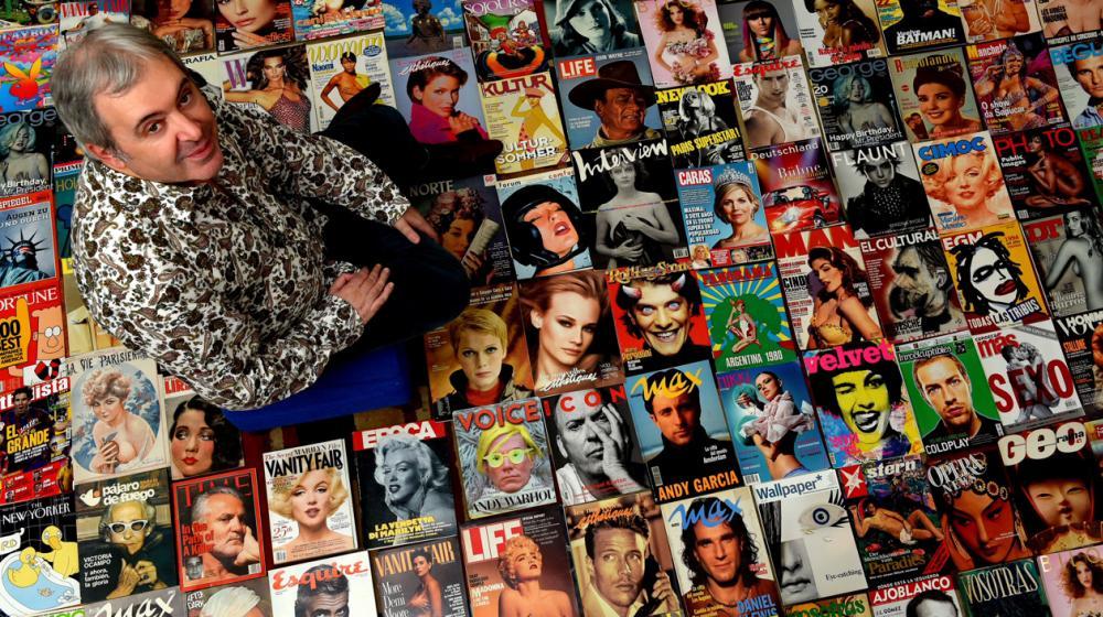 Juan Cantafio mientras posa con la colección de tapas de revistas. 