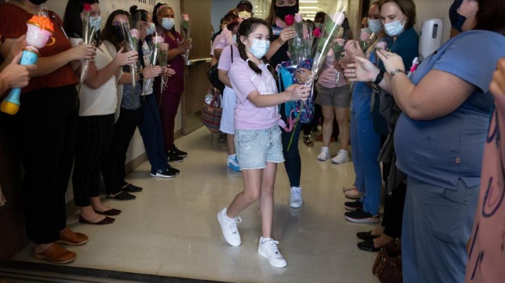 Mayah Zamora entrega flores a médicos y enfermeras que le salvaron la vida.