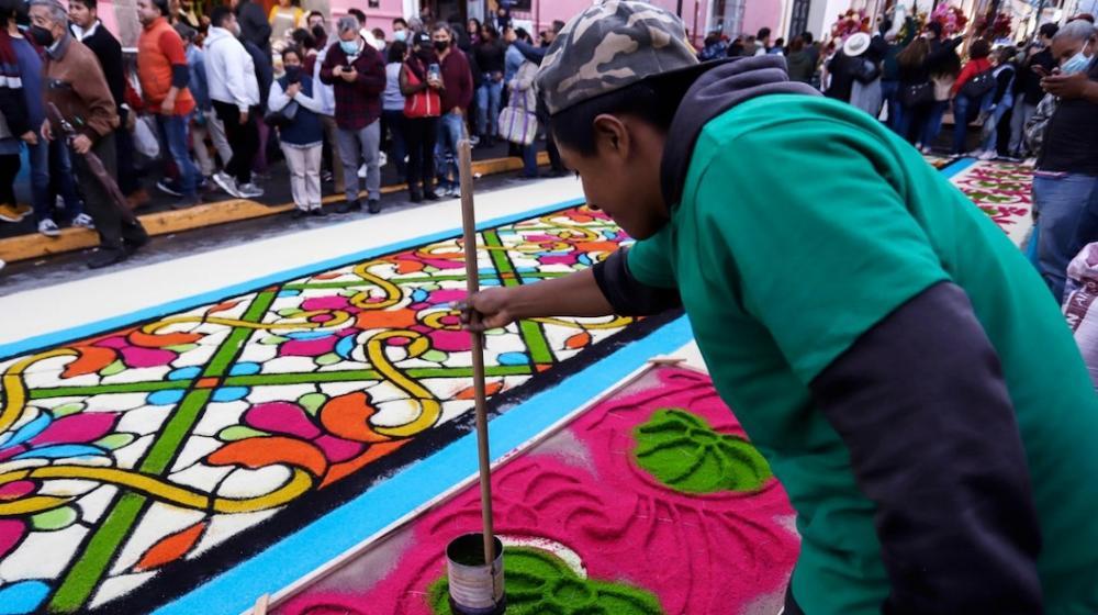 Artesanos en plena elaboración de la alfombra.
